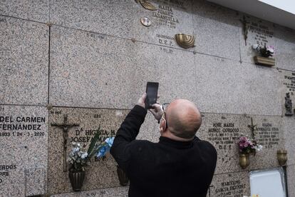 One of sons of former boxer Manuel Álvarez takes a photograph of the marker on the niche.
