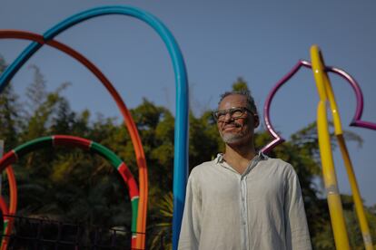 O artista Rommulo Vieira Conceição posa em frente a sua obra 'O espaço físico pode ser um lugar abstrato, complexo e em construção', em Inhotim.