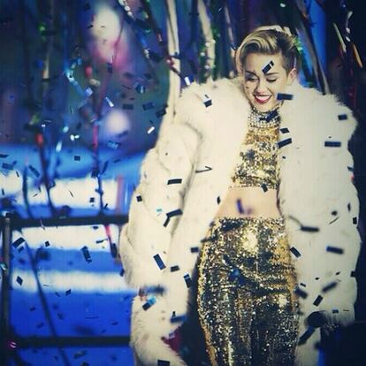 Miley no se baja de los escenario ni en estas fechas. La polémica cantante quisó cerrar el 2013 en pleno Times Square. Ataviada con un conjunto dorado de glitter y abrigo de pelo blanco, animó a los asistentes (sin sus ya frecuentes excesos) con sus temas más emblmáticos en el New Year´s Eve de la ciudad de Nueva York. Una vez más, la ex niña Disney fue la reina y estrella principal de la noche.