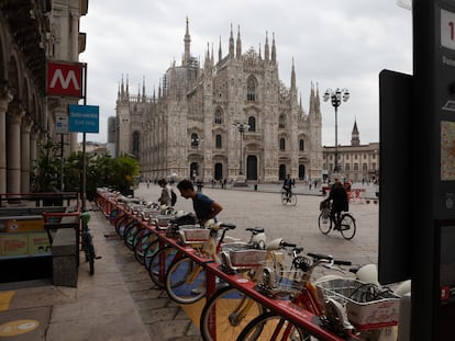 Dos usuarios sacan una bicicleta pública de una base de BikeMI, el sistema municipal de bicis de Milán, en septiembre de 2020.