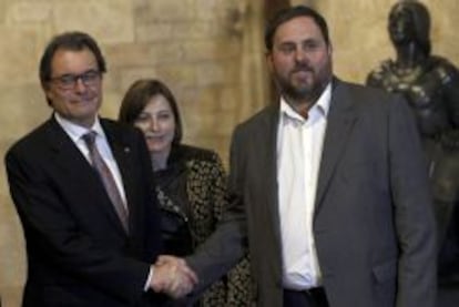 El presidente de la Generalitat, Artur Mas, y el lider de ERC, Oriol Junqueras, se estrechan la mano ante la presidenta de la Asamblea Nacional Catalana (ANC), Carme Forcadell, tras alcanzar un acuerdo sobre el adelanto electoral. 