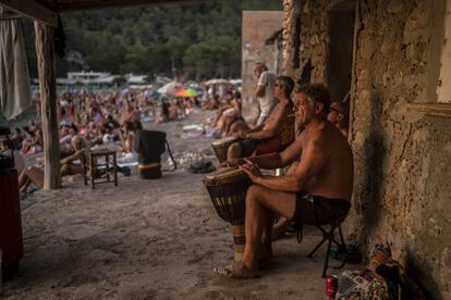 Varios hombres tocan tambores al atardecer en la cala Benirrás de Ibiza.