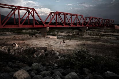 Huixtla, Estado de Chiapas. Una pareja de migrantes de origen centroamericano caminan siguiendo la vía ferroviaria cerca de Huixtla, para llegar a la pequeña ciudad de Arriaga donde podrán subirse al tren de mercancías que los llevará hacia el norte. Muchos migrantes de origen centroamericano –en su mayoría hondureños y guatemaltecos–, una vez que ingresan en México, deciden recorrer a pie los 250 kilómetros que separan la ciudad fronteriza de Tapachula de Arriaga. Este trayecto está lleno de peligros representados por la policía de migración, asaltos, secuestros y violaciones por parte de bandas organizadas. Es el comienzo del largo camino y en muchos casos el mas difícil. Esta imagen la realicé durante uno de mis primeros viajes al sur de México, aun no sabía que de alguna manera también para mí era el principio de un largo camino que me llevaría muchas a veces al sur de México para realizar el proyecto 'Dark Passge'.