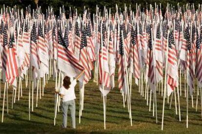 Una mujer mira una bandera con el nombre de una de las víctimas del 11-S ayer en un parque de Nueva York donde se colocaron 3.000 enseñas.