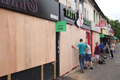 Vecinos de Northampton protegen las ventanas, en vista de los próximos disturbios en contra de la inmigración.