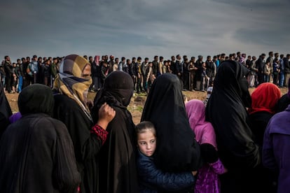 Civis que ficaram em Mosul durante a batalha para recuperar a cidade do Estado Islâmico esperam em fila para receber ajuda no bairro de Mamun (Iraque), em 15 de março de 2017. Fotografia indicada na categoria 'Photo of the Year', do fotógrafo Ivor Prickett.