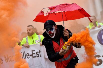 Un manifestante disfrazado sujeta una bengala durante la manifestación en Marsella (Francia). 