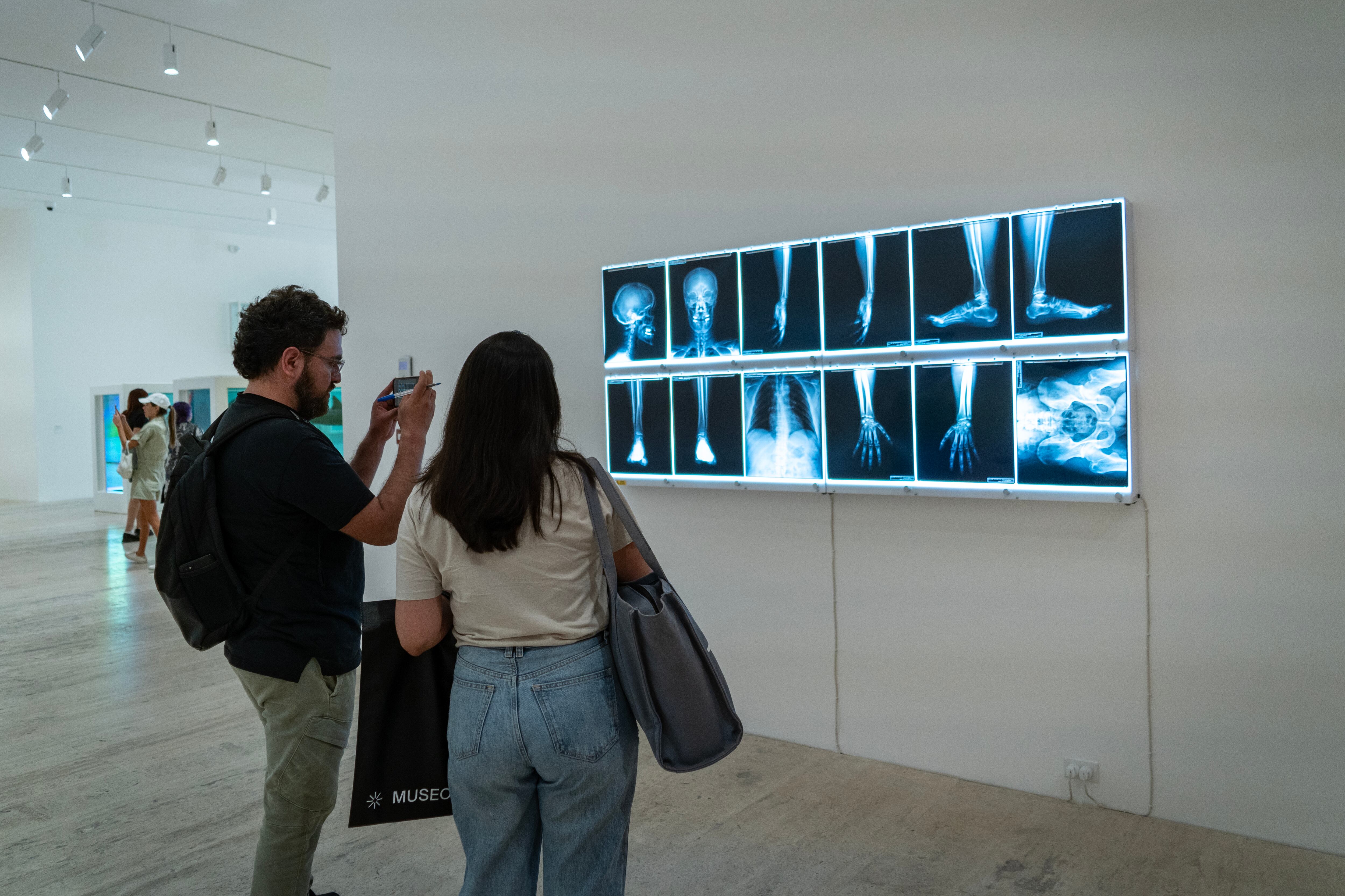 Visitantes observan un autorretrato del artista hecho con rayos X.