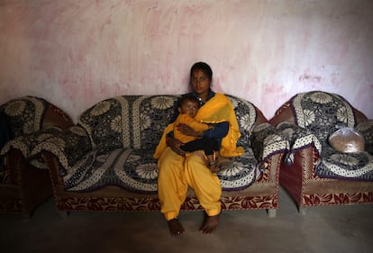 Sonu Bohra sostiene en brazos a su hijo de dos años en su casa del pueblo de Sal, en el distrito de Champawat, en Uttarakhand (India).