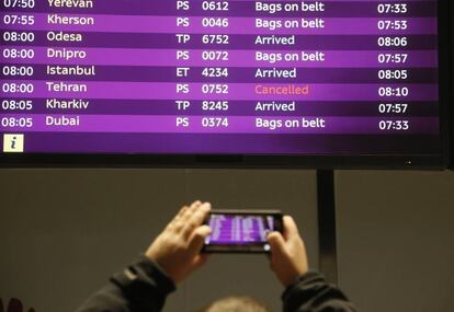 Un hombre fotografía la pantalla de una aeropuerto con varios vuelos cancelados en Ucrania.