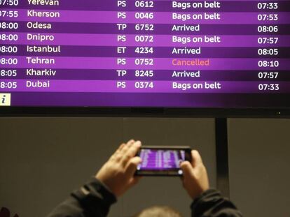 Un hombre fotografía la pantalla de una aeropuerto con varios vuelos cancelados en Ucrania.