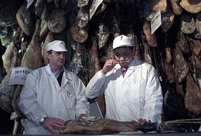 El responsable de importación de la firma británica Harrods, Andre Dang (a la derecha), y el director técnico de calidad de Sánchez Romero, Manuel Zalvide, ayer en la bodega de la empresa española en Jabugo.