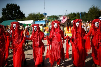 Manifestantes afiliados a 'Extinction Rebellion' participan en una procesión en el recinto del festival, el 27 de junio de 2019. 
