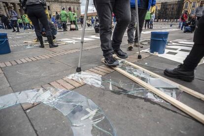 Un activista escribe en vidrio fracturado el nombre de un líder asesinado.