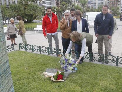 Arantza Quiroga coloca un ramo de flores ante el monolito en memoria de las víctimas en San Sebastián.
