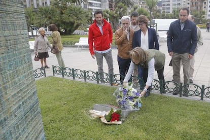 Arantza Quiroga coloca un ramo de flores ante el monolito en memoria de las víctimas en San Sebastián.