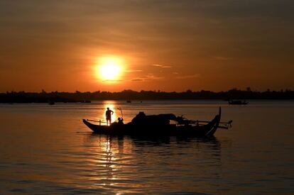 Un pescador lanza sus redes de pesca desde un barco en el río Mekong, situado en Phnom Penh.