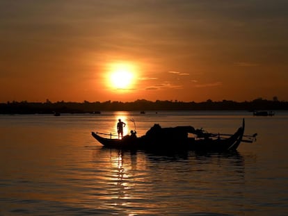 Un pescador lanza sus redes de pesca desde un barco en el río Mekong, situado en Phnom Penh.