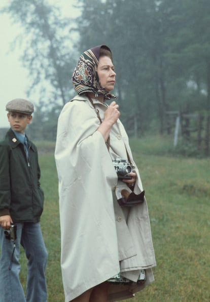 La otra corona de Isabel II. Sí, esta es una galería veraniega y, sí, esta foto pertenece a un verano. Concretamente al de 1976, cuando Isabel II asistió a los Juegos Olímpicos de Montreal para poyar a la princesa Ana, que competía en la prueba de equitación de campo a través. Vestida con un impermeable beige y un pañuelo anudado a la cabeza, y con su cámara de fotos Leica, Isabel II se manejaba a la perfección en los días lluviosos del verano. (Hulton Archive/Getty Images)