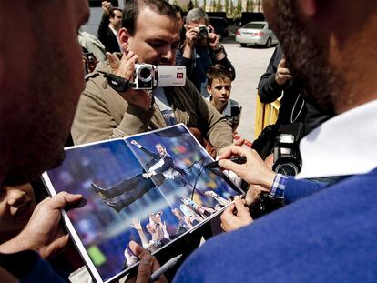 Guardiola firma una foto a un aficionado tras el entrenamiento de ayer.