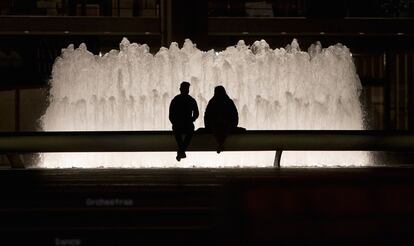 Dos jóvenes se sientan junto a la fuente del Lincoln Center en Manhattan, Nueva York.