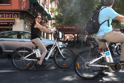 Dos usuarios del servicio BiciMad en las calles de Madrid, este martes.