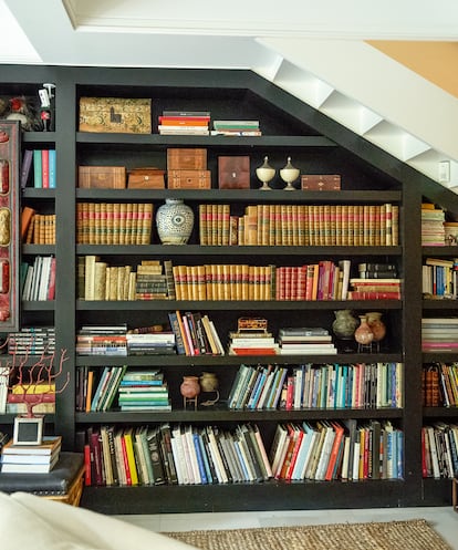 Un detalle de su biblioteca, que ocupa toda una pared bajo la escalera que conduce a la segunda planta.