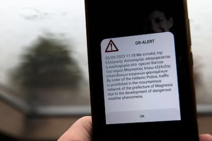 Una persona recibe un mensaje de alerta que prohíbe el tráfico en la región de Magnesia, a causa de la dana, este martes.