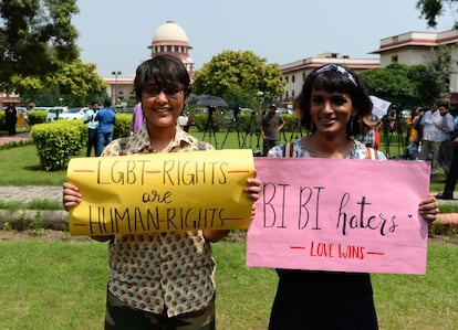 Dos miembros de la comunidad LGTB sujetan pancartas que dicen "Los derechos LGTB son derechos humanos" y "adiós enemigos, el amor gana", en Nueva Delhi (India).