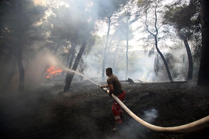 Un bombero trabaja para extinguir un incendio forestal en el pinar del pueblo de Kraps, cerca de la ciudad de Fier (Albania), el 26 de julio de 2023.