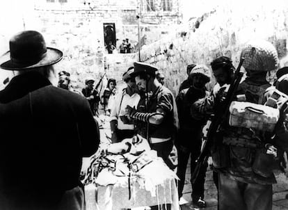 Un judío ortodoxo presta prendas de oración y filacterias para que los soldados israelíes recen en el Muro de las Lamentaciones de Jerusalén, el 8 de junio de 1967, en la Guerra de los Seis Días.