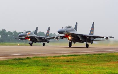 In this undated file photo released on Aug. 6, 2016, by China's Xinhua News Agency, two Chinese Su-30 fighter jets take off from an unspecified location to fly a patrol over the South China Sea.