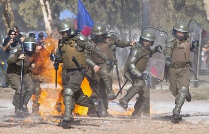 Vários policiais correm em direção oposta dos focos de incêndio provocados pelas bombas molotov.