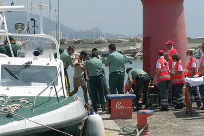 Efectivos de la Guardia Civil ayudan a desembarcar en el puerto granadino de Motril a los marroquíes.