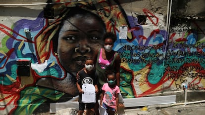 Janice Delfim, fundadora de una iniciativa para facilitar el acceso a la educación de los niños perjudicados por el cierre de escuelas por la covid-19, posa con dos de las beneficiarias de su proyecto, en la favela Prazeres de Río de Janeiro, en Brasil.