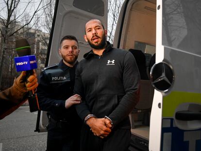 Police officers escort Andrew Tate outside the Directorate for Investigating Organized Crime and Terrorism (DIICOT) where prosecutors examine electronic equipment confiscated during the investigation in their case.