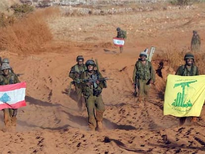 Soldados israelíes sostienen una bandera libanesa (izquierda) y otra de Hezbolá al retirarse del sur de Líbano.
