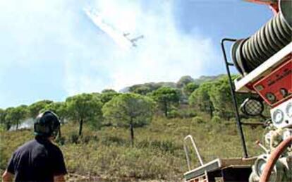 Un bombero miraba ayer la actuación de un avión en un conato de incendio registrado en la misma zona de Riotinto donde el fuego arrasó 500 hectáreas.