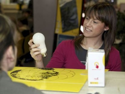 Una joven contempla una bombilla de bajo consumo 