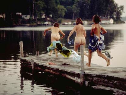 Tres mujeres de una familia finlandesa, the Kittis, saltando en un lago helado después de su sesión de sauna en Minessota (EE UU).