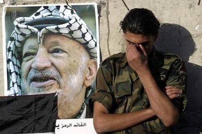 Un oficial de la seguridad palestina llora la muerte de Arafat junto a un retrato del líder en la Mukata.