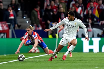 Conor Gallagher del Atlético de Madrid, cae ante la entrada de Jude Bellingham del Real Madrid.