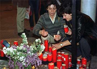 Dos periodistas encienden velas durante la concentración de esta madrugada en Córdoba por el fallecimiento de Julio A. Parrado.