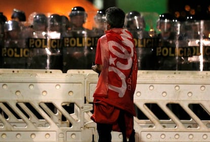 Manifestante pró-Dilma parado diante de um cordão de policiais em frente ao Congresso, onde grupos contrários ao impeachment protestaram.