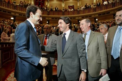 Zapatero (i) y Aznar se saludan en el Congreso de los Diputados.