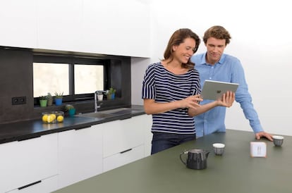 Una pareja utiliza el termostato inteligente Netatmo con una tableta de Apple.