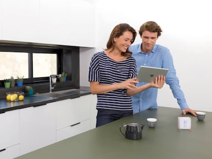 Una pareja utiliza el termostato inteligente Netatmo con una tableta de Apple.