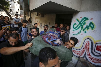 Ciudadanos palestinos desescombran un edificio tras los ataques israelíes a Deir al Balah, en el centro de Gaza, este sábado.