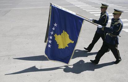 Miembros de la Fuerzas de Seguridad de Kosovo marchan con una bandera de Kosovo antes de la llegada del expresidente de Finlandia y Premio Nobel de la Paz Martti Ahtisaari en el aeropuerto internacional de Pristina 10 septiembre de 2012.