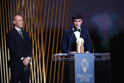 El centrocampista español del Barcelona, Pedri, pronuncia un discurso tras recibir el Trofeo Kopa al mejor jugador sub-21, flanqueado por el exfutbolista italiano Fabio Cannavaro.